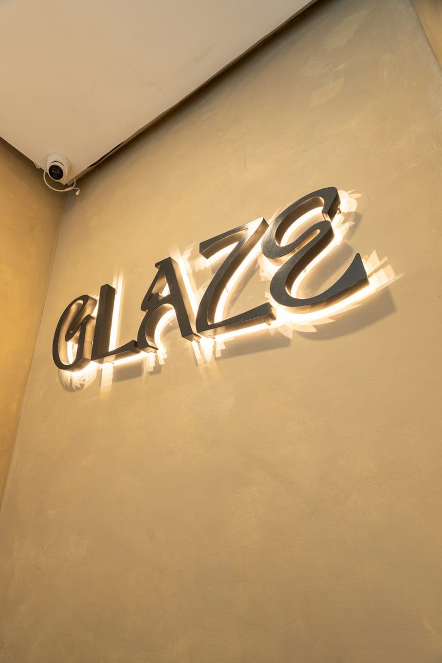 The GLAZE signature, backlit on the wall